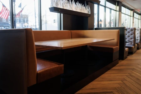 Cozy booth seating with a wooden table and large windows.