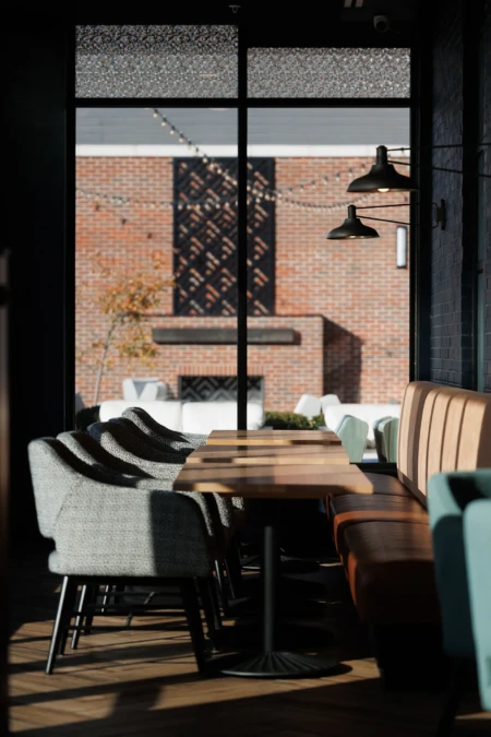 Chairs and tables arranged near large windows showcasing outdoor space.