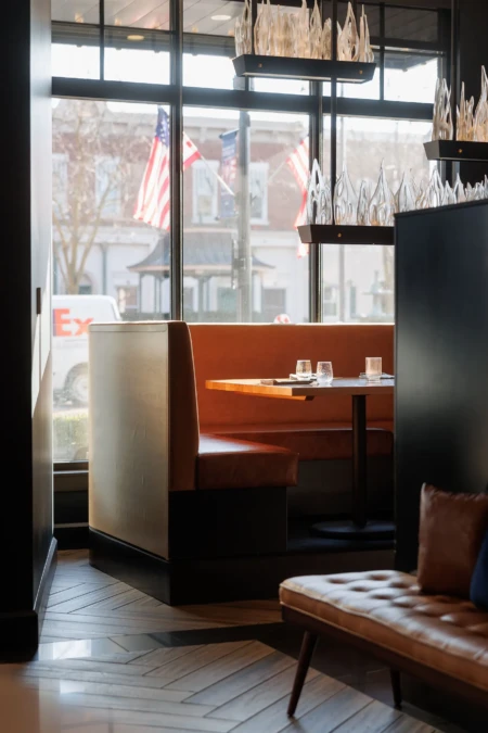 Cozy booth near large windows with decorative lighting.