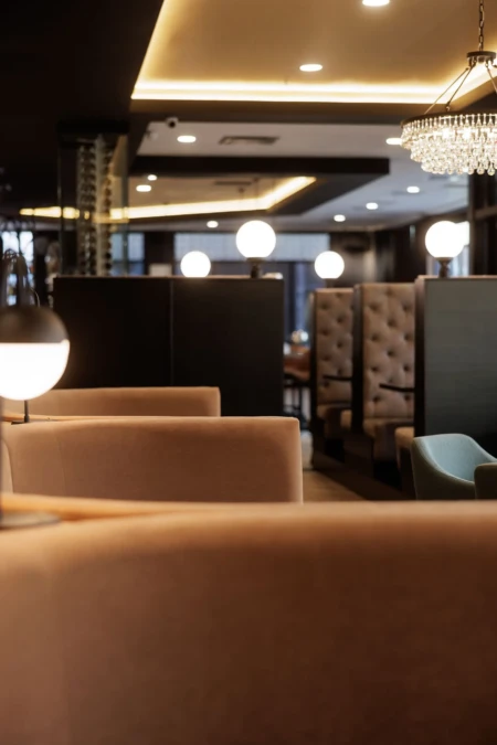 Cozy restaurant interior featuring plush seating, modern lighting, and elegant decor, creating an inviting atmosphere for dining.