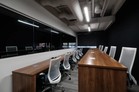 Spacious conference room with long wooden table and chairs.
