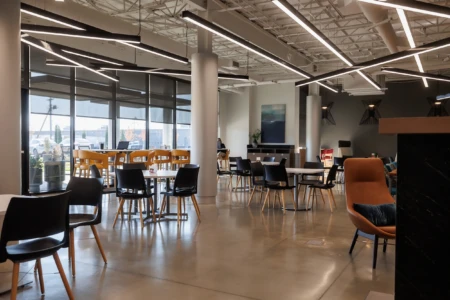 Spacious cafe with modern furniture and large windows.
